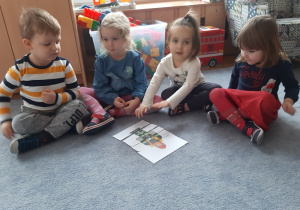 Czwórka dzieci ułożyła puzzle przedstawiające strażaka.