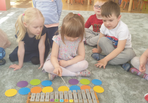 Dziewczyka gra na dzwonkach chromatycznych zakodowany kolorami układ dżwięków.