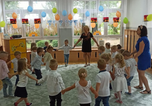 Dzieci ustawione w kole tanczą.