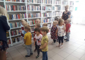 Dzieci oglądają książki w bibliotece.