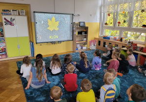 Dzieci oglądają film edukacyjny pt. "Dlaczego liście jesienią zmieniają kolor?"