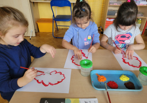 Dziewczynki malują farbami jesiennego stworka.