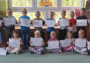 Dzieci trzymają swoje certyfikaty Code Weeku.