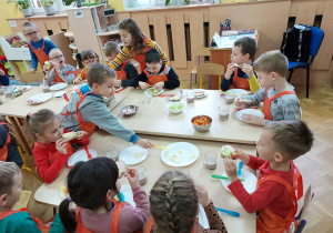 Dzieci jedzą samodzielnie przez siebie przygotowane kanapki.