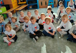 Dzieci siedząc na dywanie z uwagą słuchają legendy "O powstaniu państwa polskiego".