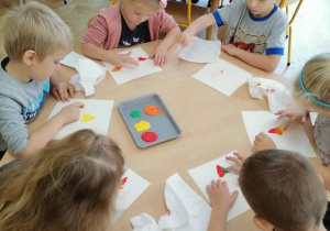 Dzieci malują sylwety liści.