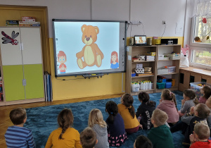 Dzieci oglądają film edukacyjny nt. historii niezwykłej maskotki.