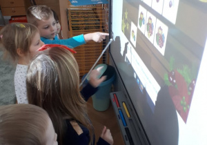 Dzieci wykonują zadanie na tablicy interaktywnej.